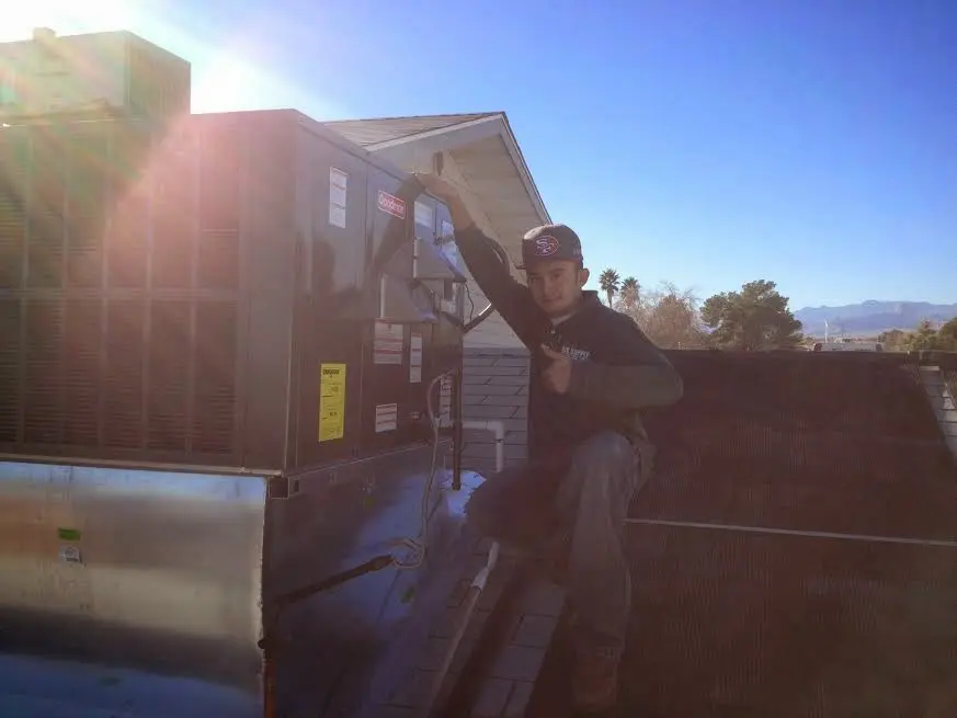 HVAC technician performing Boiler Repair on a rooftop unit in Sioux City